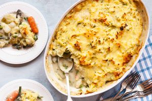 素食牧羊人派食谱——从上到下的牧羊人派勺子取出，上面是金黄酥脆的土豆泥。蓝色格子桌布，上面放着一个盛着牧羊人馅饼的盘子。